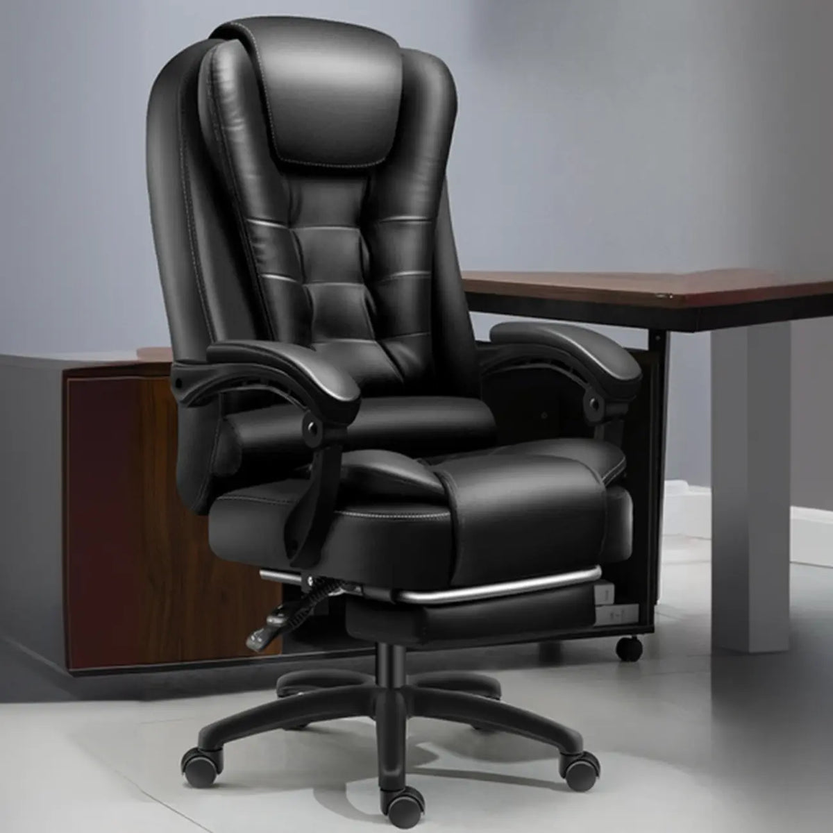 Sedia da ufficio ergonomica girevole in pelle nera con poggiapiedi